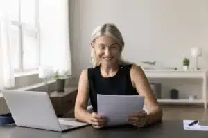 Self employed female working from home office, reading piece of paper